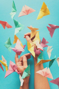 Ruh sağlığı kavramı. Renkli kağıt kadının elleri üzerinde oturan ve uçan kelebekler. Uyum duygu. Origami. Kağıdı tarzı kesin. Tonda