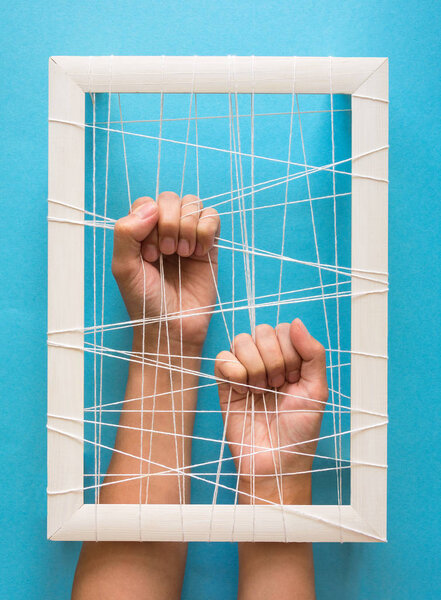 Концепция психического здоровья. Женские руки пытаются разорвать оковы на синем фоне
