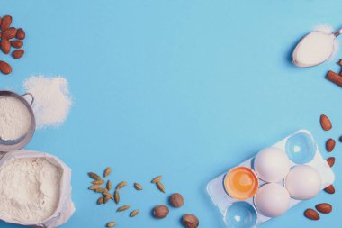 Mavi zemin üzerine ev yapımı hamur işleri için malzemeler pişirme. Tatlı pasta tatlı kavramı pişirin. Üstten görünüm. Düz yatıyordu. Uzay kopyalayın. Tonda