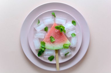 Dondurulmuş karpuz popsicleswith nane pembe plaka üzerinde. Üstten görünüm