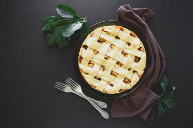 Klasik Amerikan elmalı turta koyu ahşap zemin üzerine taze pişmiş. Üstten görünüm. Uzay kopyalayın. Tonda