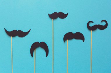 Booth dekorda mavi Kağıt arka plan üzerinde kağıt bıyık. Kesip tarzı. Movember kavramı. Üstten görünüm. Düz yatıyordu. Uzay kopyalayın. Tonda