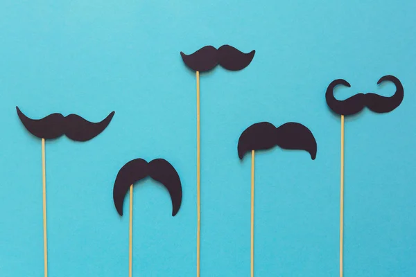 Booth dekorda mavi Kağıt arka plan üzerinde kağıt bıyık. Kesip tarzı. Movember kavramı. Üstten görünüm. Düz yatıyordu. Uzay kopyalayın. Tonda