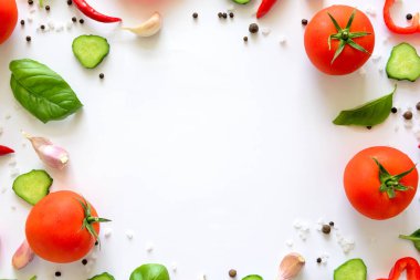 Domates, biber, biber, sarımsak, salatalık dilimleri ve fesleğen beyaz arka plan üzerinde renkli salatası malzemeler desen yapılmış. Pişirme kavramı. Üstten görünüm. Düz yatıyordu. Kopya alanı