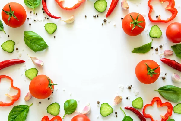 Domates, biber, biber, sarımsak, salatalık dilimleri ve fesleğen beyaz arka plan üzerinde renkli salatası malzemeler desen yapılmış. Pişirme kavramı. Üstten görünüm. Düz yatıyordu. Kopya alanı