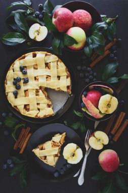 Amerikan geleneği apple pie elma, yaban mersini ve tarçın ile elma yaprakları koyu ahşap zemin üzerine dekore edilmiştir. Üstten görünüm. Düz yatıyordu. Natürmort. Tonda