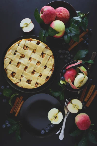 Amerikan geleneği apple pie elma, yaban mersini ve tarçın ile elma yaprakları koyu ahşap zemin üzerine dekore edilmiştir. Üstten görünüm. Düz yatıyordu. Natürmort. Tonda