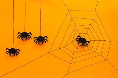 Siyah kağıt örümcek web üzerinde sarı arka plan ile. Cadılar Bayramı kavramı. Kağıdı tarzı kesin. Üstten görünüm