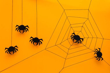 Siyah kağıt örümcek web üzerinde sarı arka plan ile. Cadılar Bayramı kavramı. Kağıdı tarzı kesin. Üstten görünüm