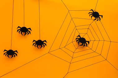 Siyah kağıt örümcek web üzerinde sarı arka plan ile. Cadılar Bayramı kavramı. Kağıdı tarzı kesin. Üstten görünüm