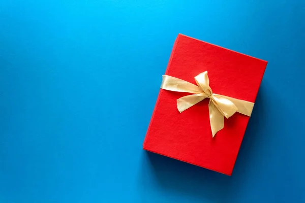 赤のクリスマス ギフト ボックスの上面リボン青い紙の背景に飾られています 年始の休日のお祝いの装飾の概念 領域をコピーします フラットを置く — ストック写真