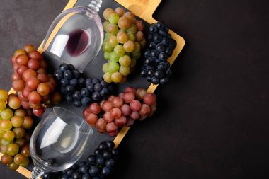 Kırmızı ve beyaz şarap, üzüm, corkcrew ve koyu ahşap arka plan üzerinde yalan mantarlar iki kadehlerin. Üstten görünüm. Düz yatıyordu. Kopya alanı