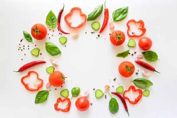 Domates, biber, biber, sarımsak, salatalık dilimleri ve fesleğen beyaz arka plan üzerinde renkli salatası malzemeler desen yapılmış. Pişirme kavramı. Üstten görünüm. Düz yatıyordu. Kopya alanı