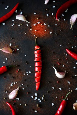 Olgun kırmızı biber biber, sarımsak, bakla, bezelye ve koyu ahşap arka plan üzerinde yalan toz dilimlenmiş. Üstten görünüm. Düz yatıyordu