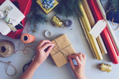 Kadının elleri gri ahşap arka plan üzerinde mevcut kutu süslemeleri. Yeni yıl ve Noel süslemeleri kavramı. Tonda