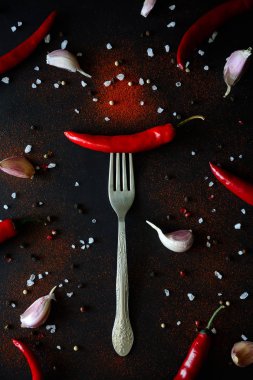 Ham Olgun kırmızı biber biber biber bezelye ve koyu ahşap arka plan üzerinde yalan toz çatalla üzerinde. Üstten görünüm. Düz yatıyordu