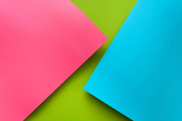 Синий, зеленый и розовый бумажный фон. Громоздкая геометрическая плоскость. Вид сверху. Копирование пространства
