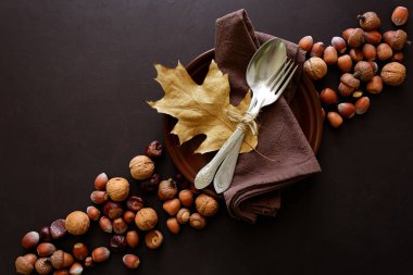 Sofra, ceviz, fındık, kestane ve meşe palamutları koyu ahşap zemin üzerinde. Şükran günü tatil kavramı. Üstten görünüm. Düz yatıyordu. Kopya alanı