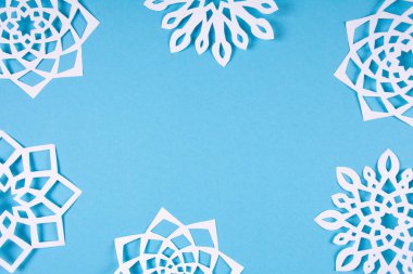 Kağıt kar taneleri mavi arka plan karede. Üstten görünüm. Noel dekorasyonu. Tonda