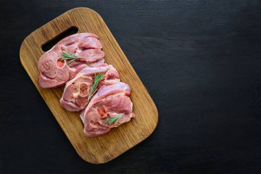 Çiğ hindi biftek eti kemik üzerinde ahşap tahta arka plan ile