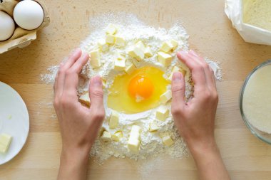 Ellerini kurabiye hamur ile çalışma. Hazırlama kek malzemelerle ahşap masa arka plan yapma. Düz yatıyordu. Üstten görünüm.