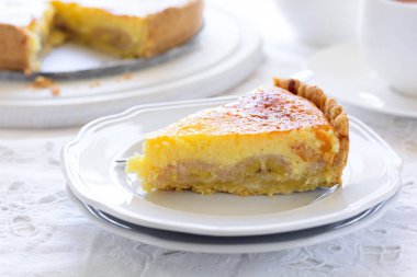 Beyaz tabloda çay bardağı ile lezzetli Muz pasta (cheesecake). Çay saati kavramı. Kopya alanı