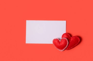 Keçe sevgi kalpleri ve tebrik kartı kırmızı Kağıt arka plan üzerinde mevcut kutusu. Sevgililer günü kutlama kavramı. Üstten görünüm. Düz yatıyordu.