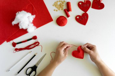 Sevgililer günü el sanatları hissettim. Eller kadın dikiş kırmızı kalpler. DIY. Düz yatıyordu. Üstten görünüm