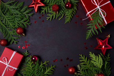 Kırmızı hediye kutuları, köknar şube, konfeti ve siyah arka plan üzerine oyuncaklar Noel çerçeve. Düz yatıyordu. Üstten görünüm. Kopya alanı