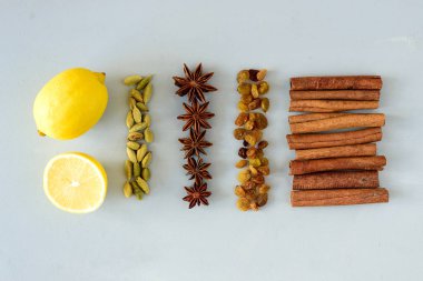 Gri ahşap masa üzerinde mulled şarap tarifi Malzemeler. Noel veya içki ısınma kış. Bir şişe şarap, limon, tarçın, anason, Kakuleden, Kuru üzüm. Üstten görünüm. Düz yatıyordu