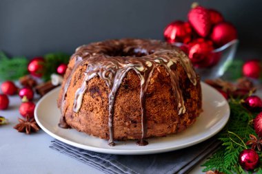 Noel kek gri ahşap zemin üzerine çikolata sosu ile. Tatil dekorasyon konsepti