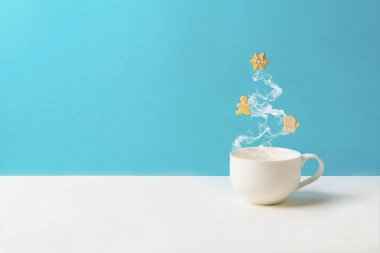Fincan çay ya da kahve gingerbread çerezleri üzerinde mavi arka plan ile köknar ağacı durumda buhar ile. Noel kutlamaları kavramı. Uzay kopyalayın. Tonda