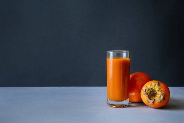 Trabzon hurması suyu gri ahşap arka plan üzerinde hurma ile. Sağlıklı beslenme kavramı. Kopya alanı.