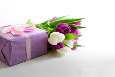 Beyaz ve mor laleler ve hediye kutusu beyaz ahşap zemin üzerinde buket. Üstten görünüm. Düz yatıyordu. Uzay kopyalayın. Sevgililer günü, anneler günü, Doğum günü, düğün kutlama kavramı.