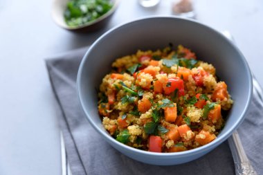 Quinoa, kabak, biber ve gri ahşap zemin üzerine havuç ile sağlıklı vegan kase. Seçici odak