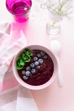 pembe bir arka plan üzerinde muz ile sağlıklı berry güler yüzlü kase. Vejetaryen gıda veya detoks kavramı. Seçici odak