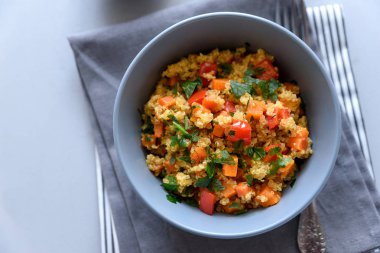 Quinoa, kabak, biber ve gri ahşap zemin üzerine havuç ile sağlıklı vegan kase. Seçici odak