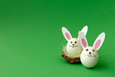 Yumurta ve yeşil pastel renkli kağıt kulaklara yapılan Paskalya tavşanı sepetle. Yaratıcı bir fikir. Sanat gıda kavramı.
