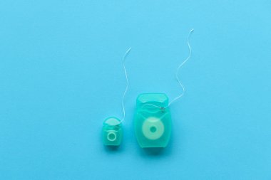 Mavi arka plan üzerinde yakın çekim diş ipi. Üstten Görünüm. Dişlerle ilgili sağlık bilgisi ve bakım kavramı