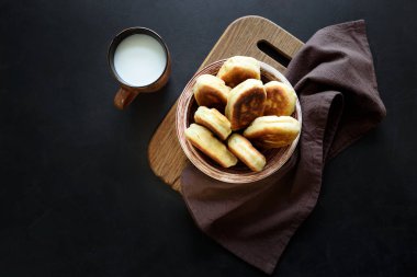 Fried köftesi ya da pies yeşil soğan ve koyu ahşap arka plan üzerinde yumurta dolu. Pirozhki Rus geleneği gıda.