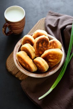 Fried köftesi ya da pies yeşil soğan ve koyu ahşap arka plan üzerinde yumurta dolu. Pirozhki Rus geleneği gıda.