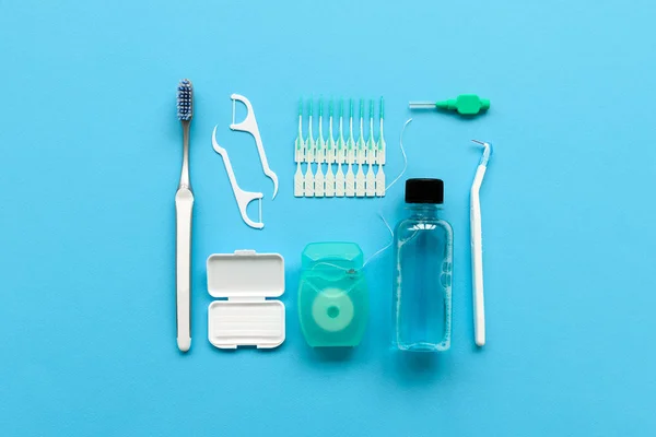 Mavi arka plan üzerinde diş bakımı için farklı araçlar. Diş fırçası, temizleyici, ipi, flossers, diş telleri ve interdental fırça için balmumu. Üstten Görünüm. Düz yatıyordu. Dişlerle ilgili sağlık bilgisi ve bakım kavramı