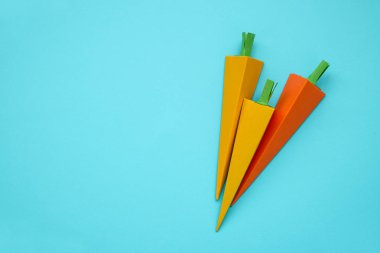 Kağıt mavi arka plan üzerinde yapılan havuç. Taze sebze. En az, yaratıcı, vegan, sağlıklı veya gıda sanat kavramı. Uzay kopyalayın. Üstten Görünüm