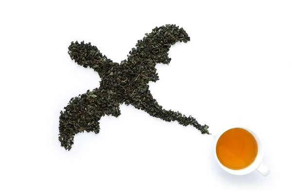 Tasse Tee und Drache aus trockenem grünem Tee auf weißem Hintergrund — Stockfoto
