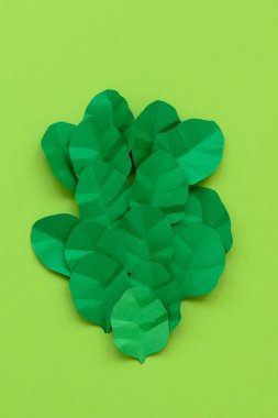Yeşil arka planda Kağıt yapılmış ıspanak yaprakları. Minimal, yaratıcı, Vegan, sağlıklı veya gıda sanat kavramı. Düz yatıyordu. Üst görünüm