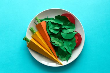 Kağıttan yapılmış sebze ile plaka: havuç, domates, ıspanak ve roka mavi zemin üzerine. En az, yaratıcı, vegan, sağlıklı veya gıda sanat kavramı. Uzay kopyalayın. Üstten Görünüm
