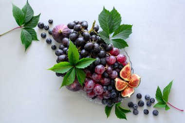 Taze organik mevsim meyveleri: üzüm, incir ve yaban mersini. Gri ahşap arka plan üzerinde Sonbahar hasat. Üstte görüntü