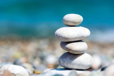 Bulanık deniz arka plan ile çakıl plajda Taşlar piramit. Seyahat ve dinlenme konsepti