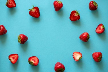 Mavi arkaplanda çilek çerçevesinin üst görüntüsü. Yaz doğası geçmişi. Böğürtlen deseni Düz yatıyordu