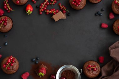 Çerçeve çikolatalı kekler, çikolata barlar, kakao ve çilek koyu ahşap arka plan üzerinde. Üst te. Düz yatıyordu